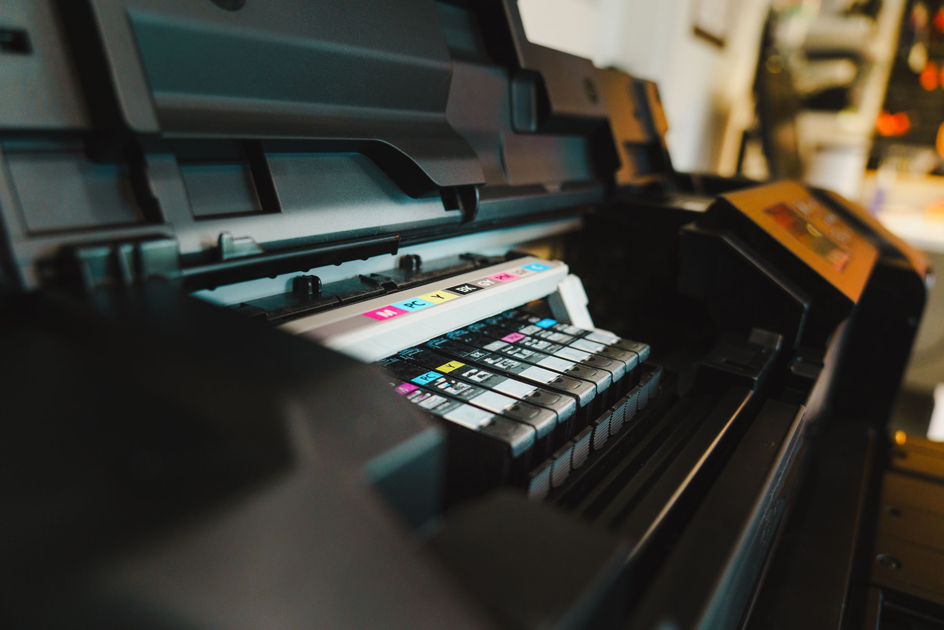 Wide-format printer loaded with color ink cartridges producing print marketing materials